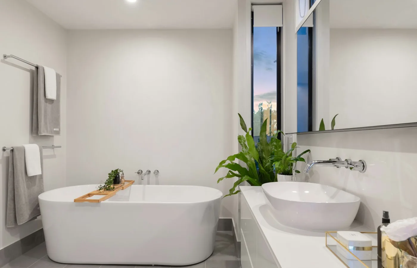 Helles Badezimmer mit freistehender Badewanne, Waschbecken und Pflanzen