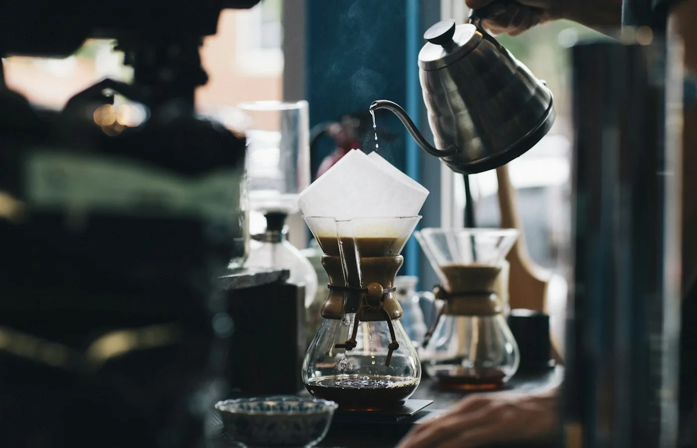 Kaffeezubereitung mit Filter, Glaskanne und Kaffeemühle auf einer Arbeitsfläche